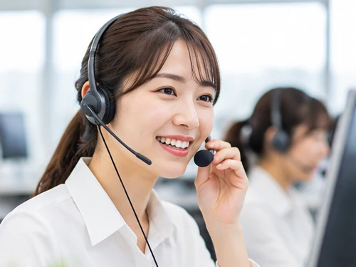 ヘッドセットで電話を受け付けるオペレーター