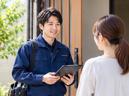 作業服でお客様宅を訪問するスタッフ